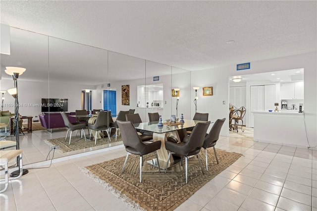 tiled dining space featuring a textured ceiling