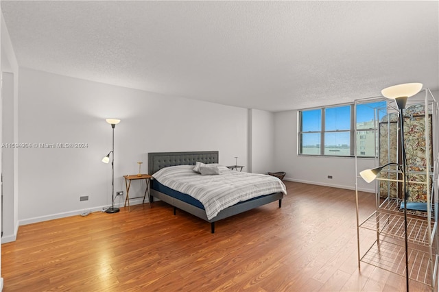 bedroom featuring wood-type flooring and a textured ceiling