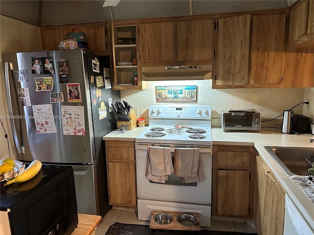 kitchen featuring wall chimney exhaust hood, sink, white appliances, and light tile patterned floors