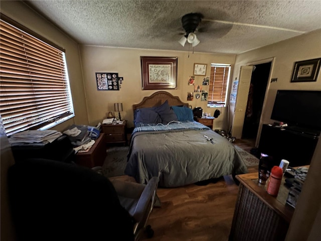 bedroom featuring a ceiling fan, a textured ceiling, and wood finished floors