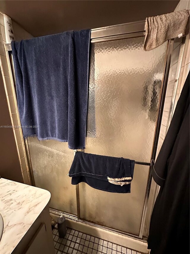 bathroom featuring tile patterned floors, vanity, and an enclosed shower