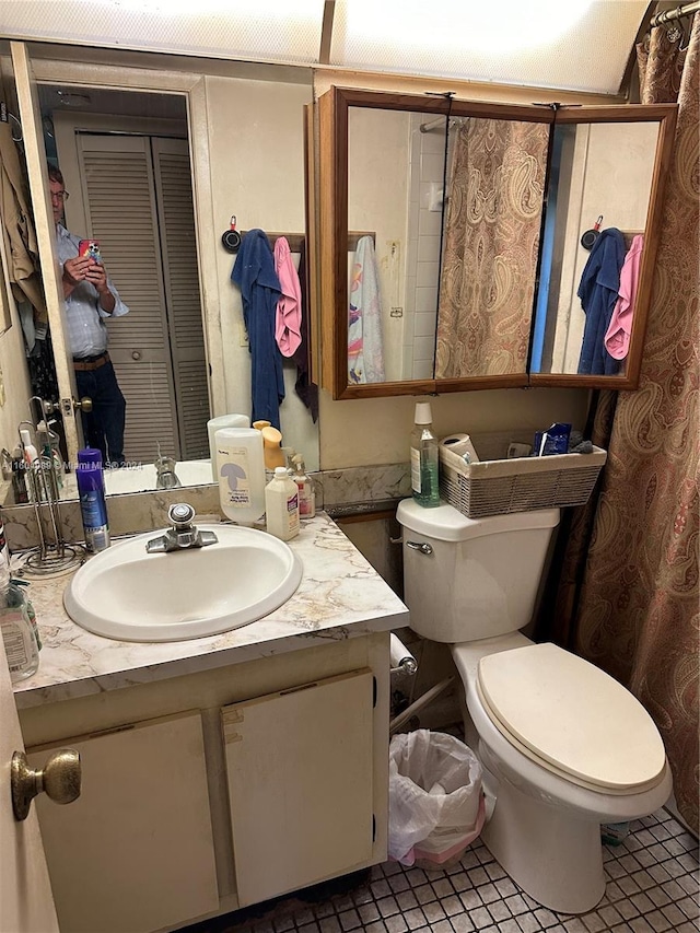 bathroom with toilet, a closet, and vanity