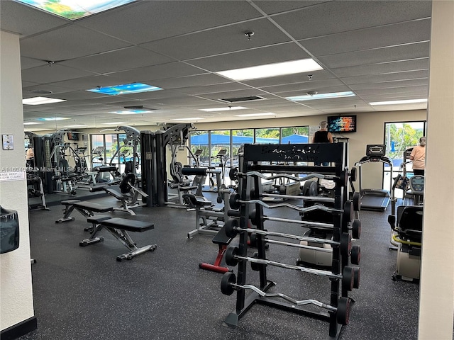 workout area with a drop ceiling and a healthy amount of sunlight