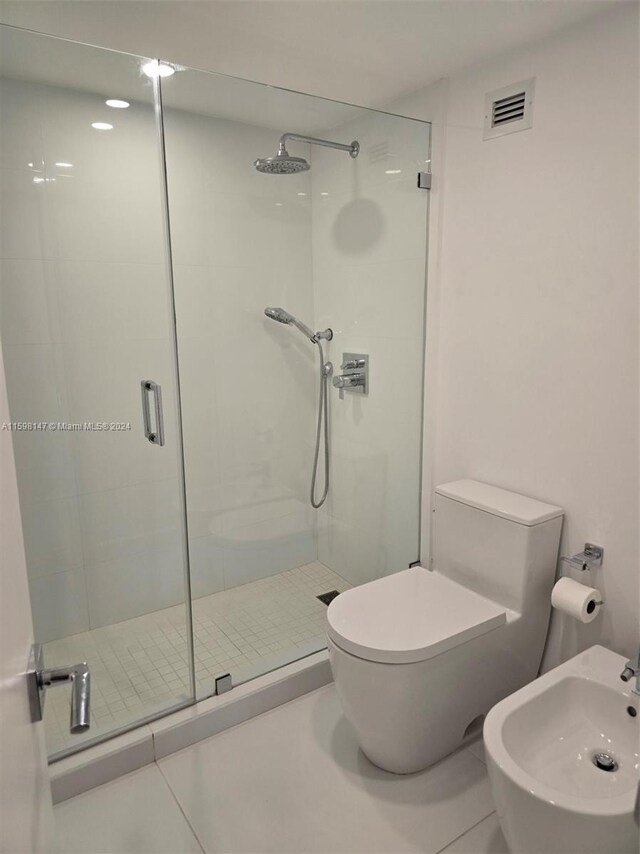 bathroom with tile floors, a bidet, an enclosed shower, and toilet