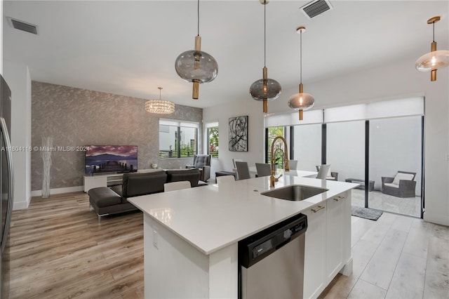 kitchen with a center island with sink, sink, white cabinetry, appliances with stainless steel finishes, and light hardwood / wood-style floors