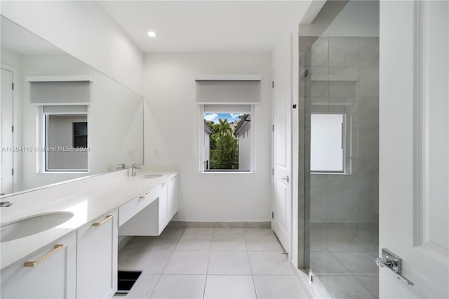 bathroom with vanity, a tile shower, and tile patterned flooring