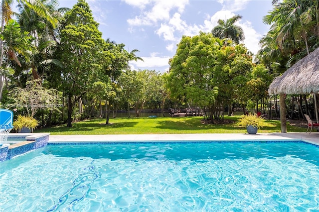 view of pool with a lawn