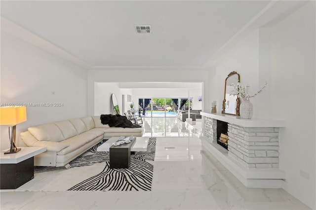 tiled living room with a stone fireplace