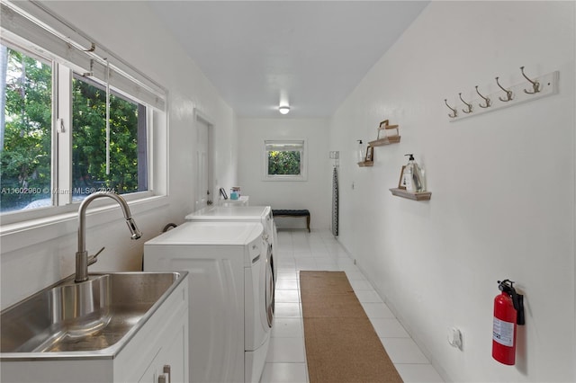 laundry area featuring plenty of natural light, light tile patterned floors, and washer and dryer