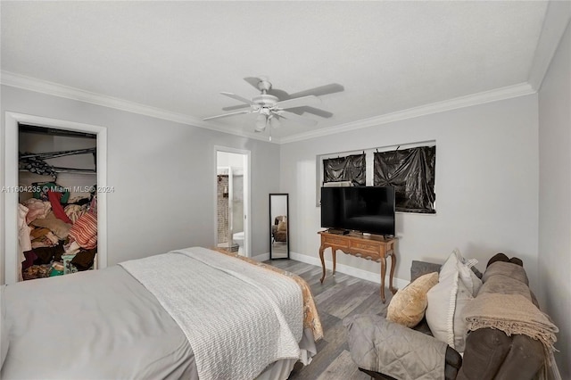 bedroom featuring light hardwood / wood-style floors, ensuite bath, ceiling fan, and crown molding