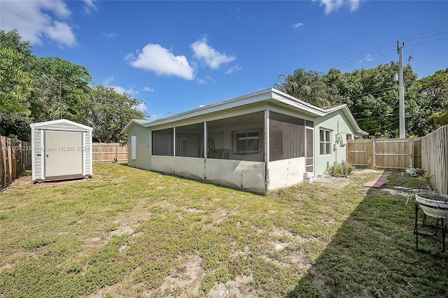 back of house with a sunroom, a shed, and a yard