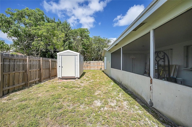 view of yard with a sunroom and a storage shed