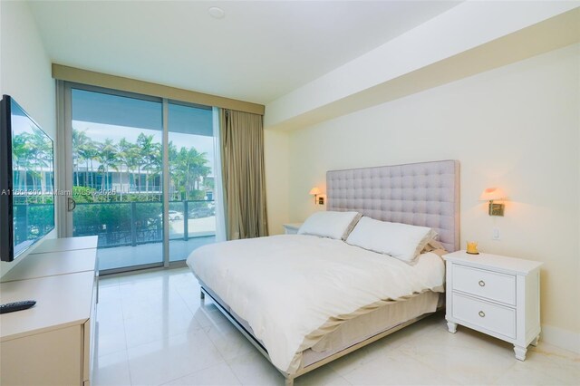 tiled bedroom featuring access to exterior and a wall of windows