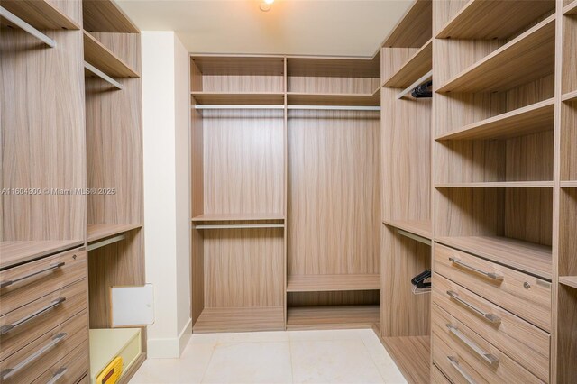 spacious closet featuring light tile floors