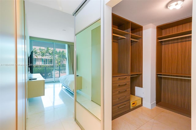 walk in closet featuring light tile floors