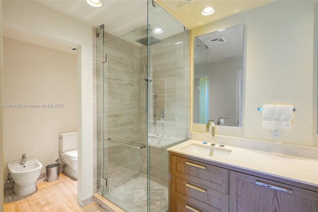 bathroom with walk in shower, a bidet, wood-type flooring, large vanity, and toilet