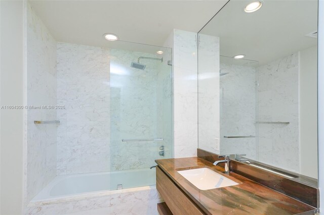 bathroom with tiled shower / bath and vanity