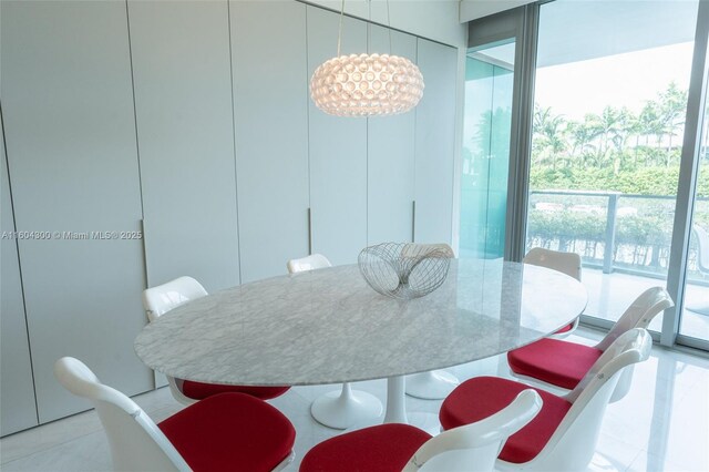 dining room with a notable chandelier, expansive windows, and light tile floors