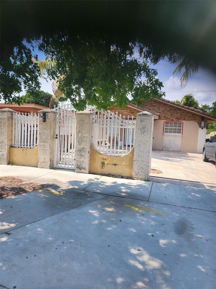 827 E 27th St, Hialeah, FL 33013 - view of gate featuring a fenced front yard