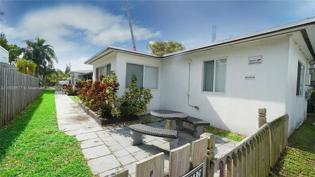 exterior space featuring fence, a patio, and stucco siding