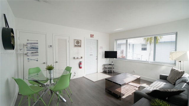 living room featuring baseboards and dark wood-style flooring