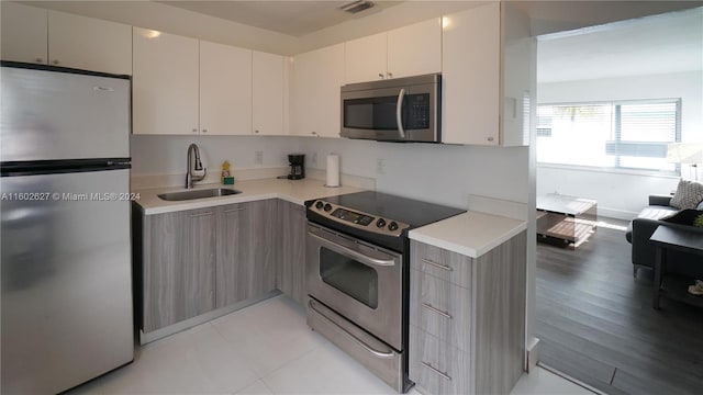 kitchen with visible vents, modern cabinets, stainless steel appliances, light countertops, and a sink