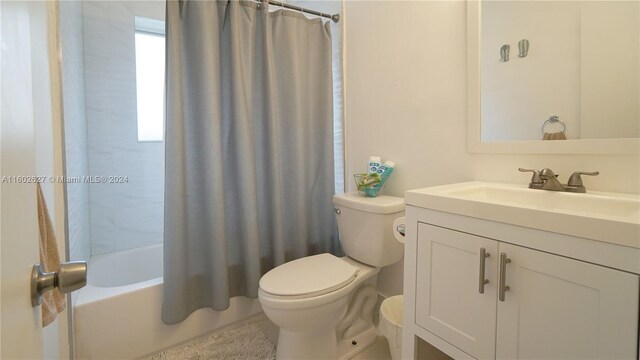 full bathroom featuring shower / bath combo with shower curtain, vanity, and toilet