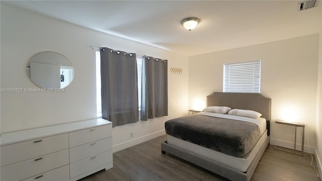 bedroom featuring dark wood-style floors, visible vents, and baseboards