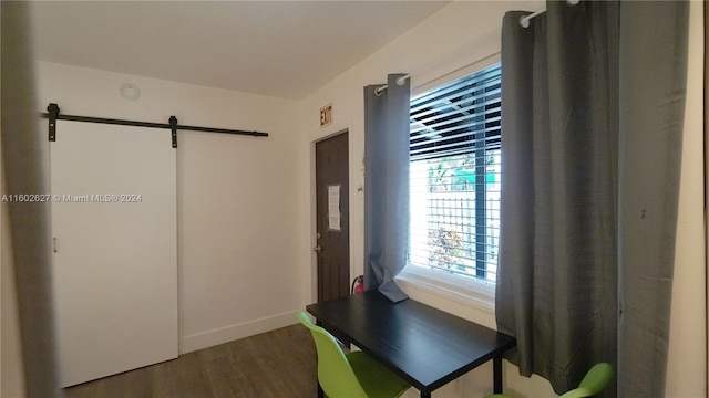 office space with wood-type flooring and a barn door