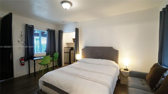 bedroom featuring dark hardwood / wood-style floors and stainless steel fridge