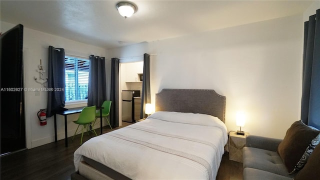 bedroom with dark wood-type flooring and baseboards