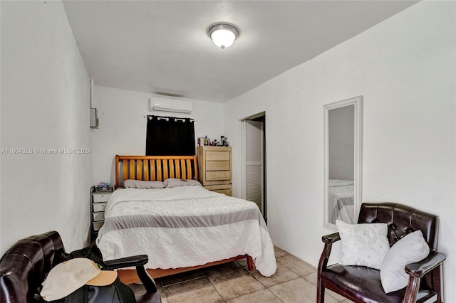 bedroom featuring light tile patterned flooring and an AC wall unit