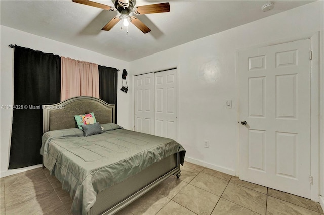 tiled bedroom with ceiling fan and a closet