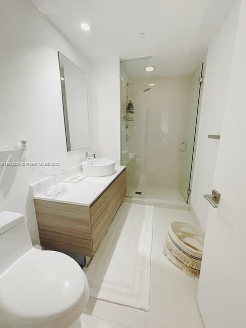 bathroom featuring tile patterned floors, vanity, an enclosed shower, and toilet