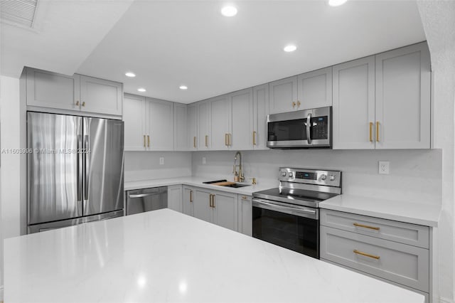 kitchen with sink, gray cabinets, and appliances with stainless steel finishes