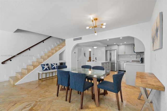 dining room featuring sink and a chandelier