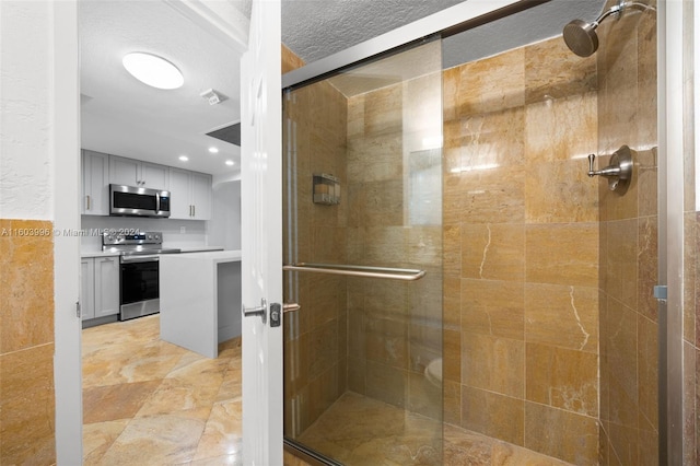 bathroom featuring an enclosed shower and a textured ceiling