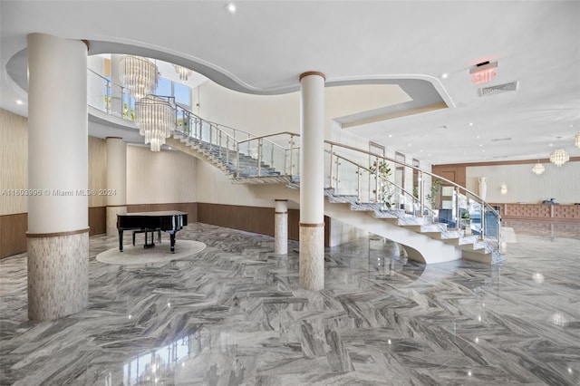 stairway with decorative columns and a chandelier