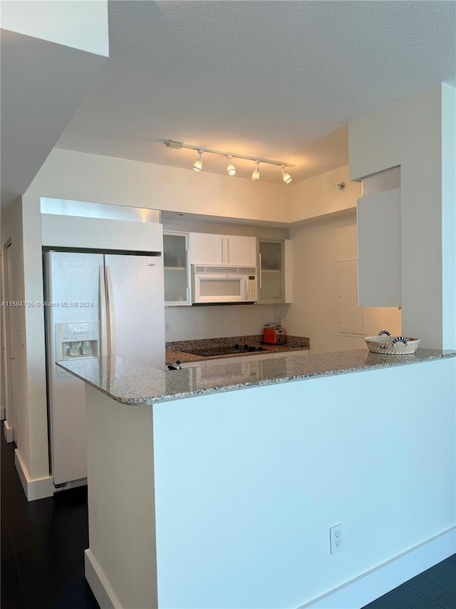 kitchen with white cabinetry, light stone countertops, white appliances, and rail lighting