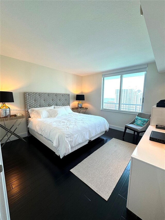 bedroom with dark hardwood / wood-style floors