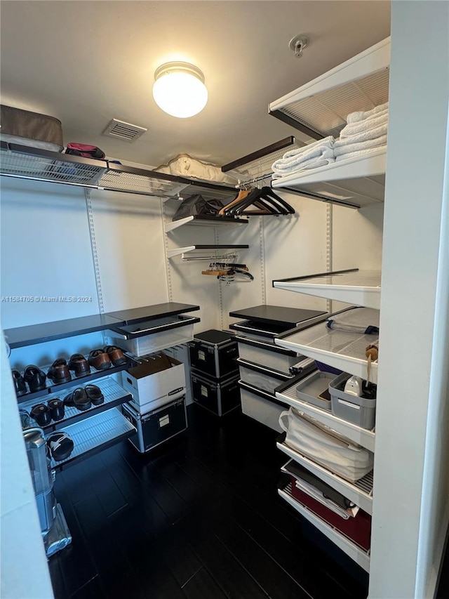 walk in closet with dark hardwood / wood-style flooring