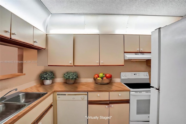 kitchen featuring white appliances, sink, and cream cabinets