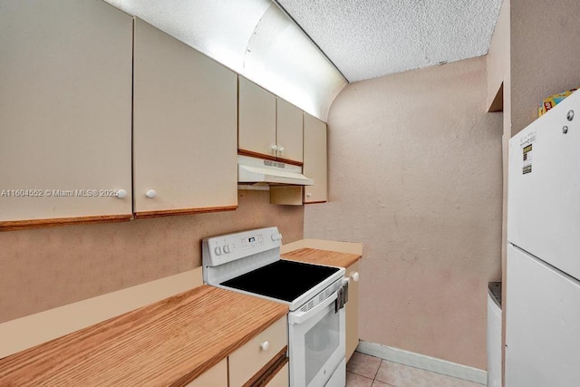 kitchen with a textured ceiling, white appliances, and light tile patterned flooring