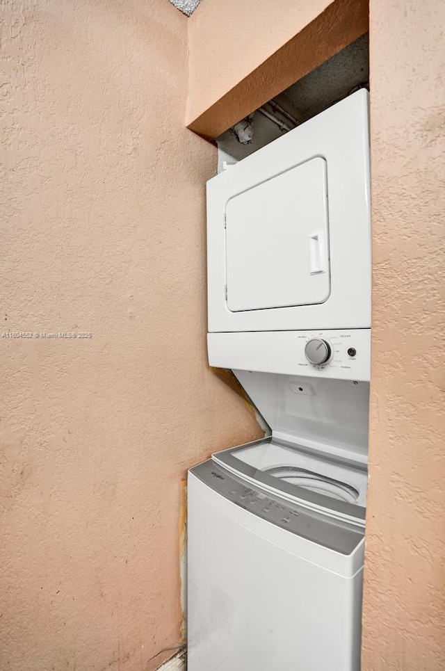 clothes washing area with stacked washer and clothes dryer