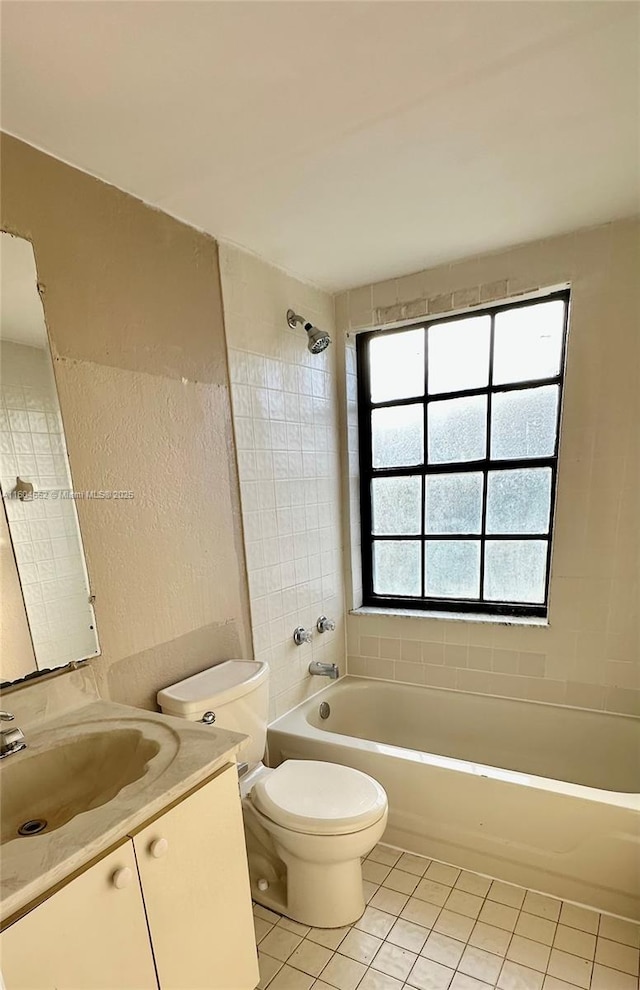 full bathroom with tile patterned floors, tiled shower / bath, vanity, and toilet