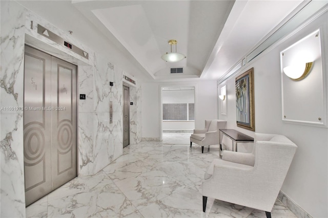 interior space featuring elevator, tile patterned flooring, and a tray ceiling