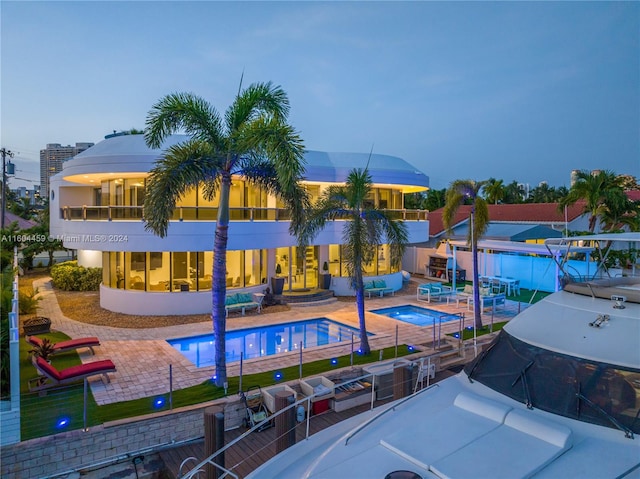 pool at dusk featuring a patio area