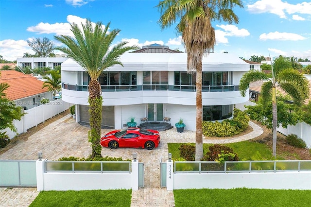 3344 NE 167th St, North Miami Beach, FL 33160 - view of building exterior featuring an attached garage, decorative driveway, and a fenced front yard