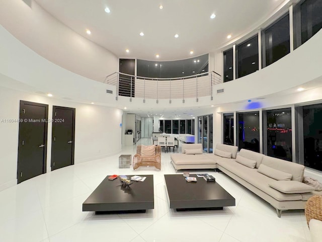 living room featuring light tile patterned flooring and a towering ceiling