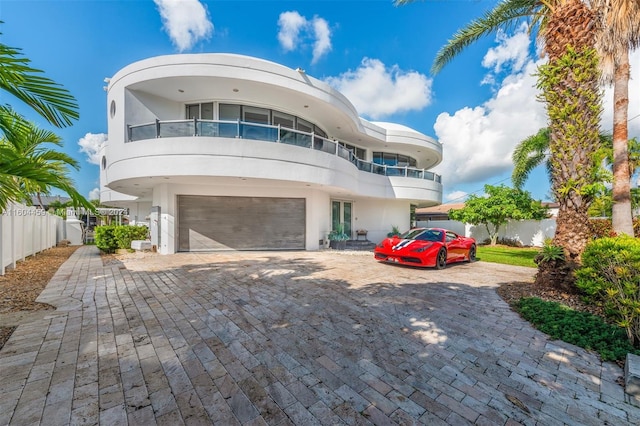 art deco home with a garage and a balcony